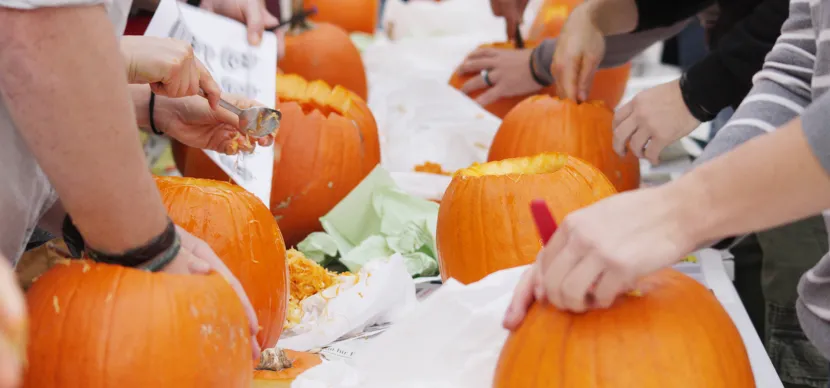 students carving pumpkin