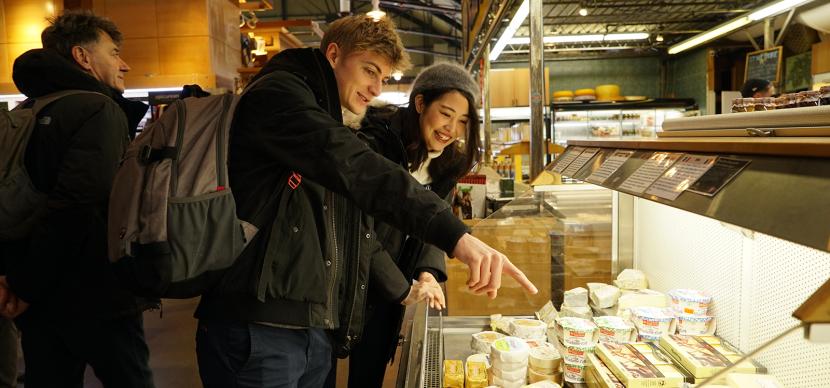 students looking at food in a market