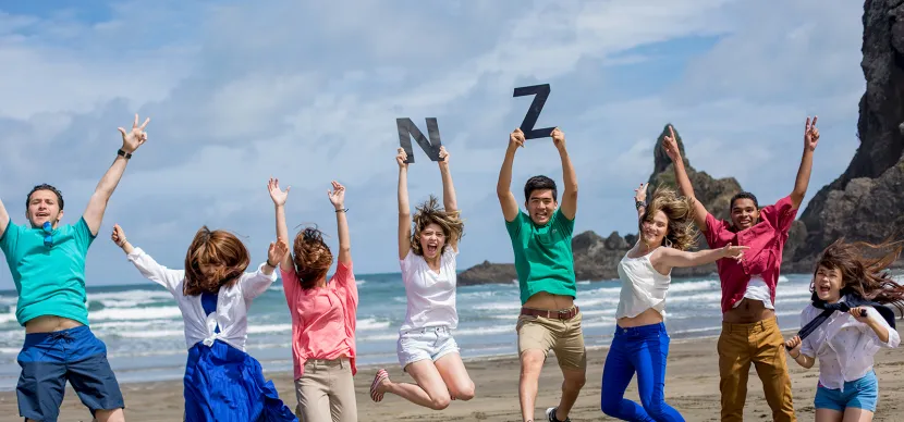 students jumping at a beach
