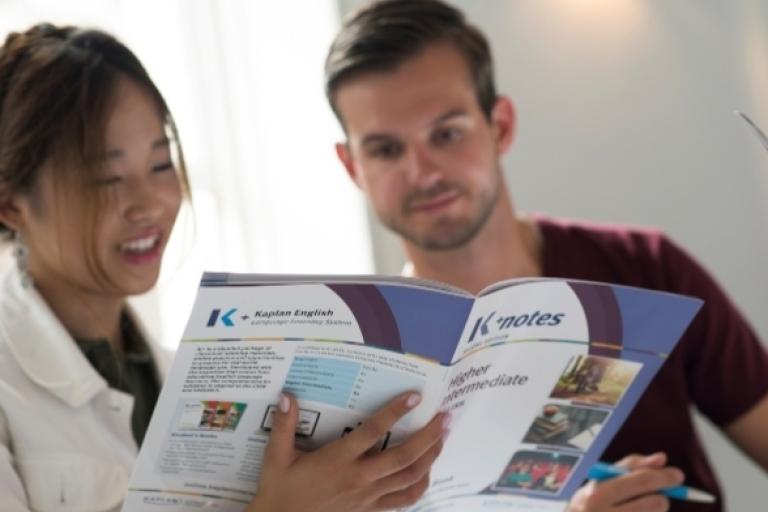 Students holding a Kaplan book