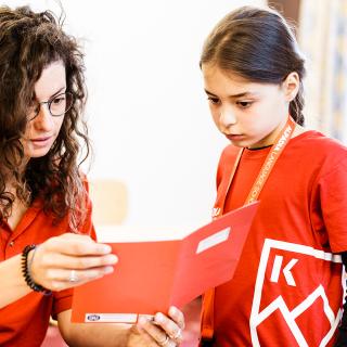 teacher and students looking at a book