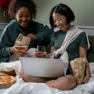 girls watching a movie together on a laptop